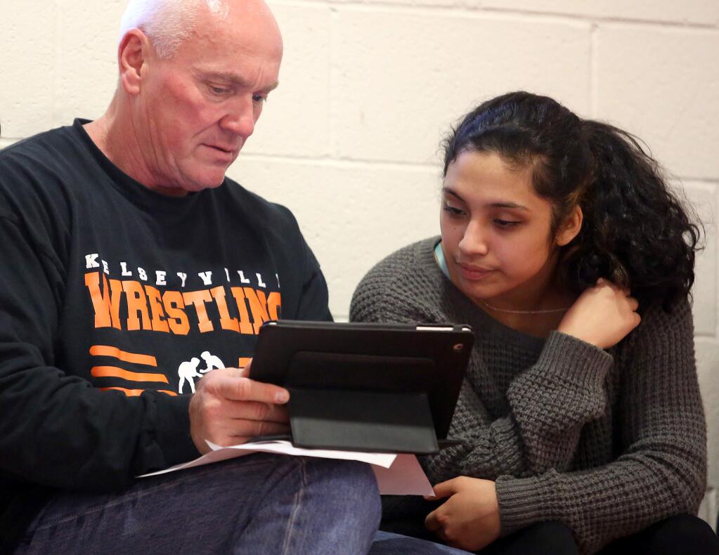 Kelseyville's Marina Beckwith, right, checks out the brackets with Kelseyville wrestling coach Rob Brown prior to the start of the wrestling match held at St. Helena High School, Wednesday, February 11, 2015. (Crista Jeremiason/The Press Democrat)