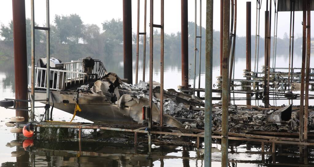 The stern of a boat burned to the water line by a fire at the Walnut Grove Marina in the Sacramento-San Joaquin Delta community of Walnut Grove, Calif., Monday Jan. 26, 2015. More than a dozen boats were destroyed or damaged by the fire, which started just after midnight Monday. Investigators have not listed a cause for the fire. (AP Photo/Rich Pedroncelli)
