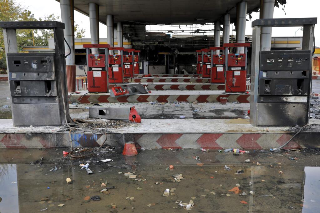 FILE - In this Nov. 20, 2019, file photo, rainwater pools at a gas station attacked during protests over government-set gasoline prices in Tehran, Iran. Amnesty International says at least 208 people in Iran have been killed amid protests over sharply rising gasoline prices and a subsequent crackdown by security forces. The country has yet to release any nationwide statistics about the unrest last month. (AP Photo/Ebrahim Noroozi, File)
