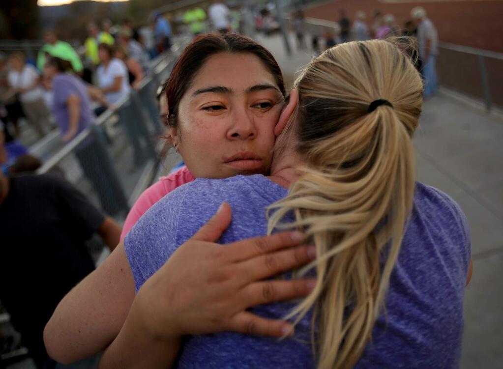 Seeing each other for the first time since the Valley fire began, Maria Fonseca, left and Tanya Drew, both lost their Middletown homes to the fire, Thursday Sept. 24, 2015. The two were at a meeting at the Middletown High School for residents to learn about the options of clean-up and re-building. (Kent Porter / Press Democrat) 2015