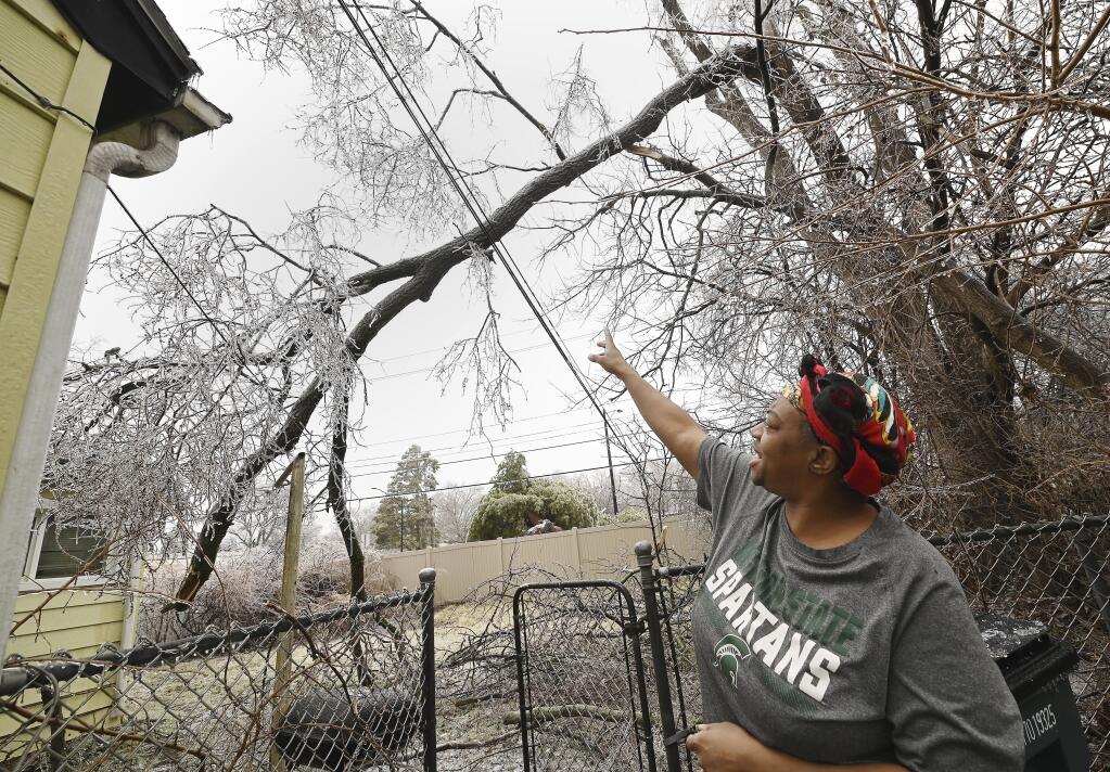 Jenett Johnson, 48, talks about the fallen tree and damaged wires from the ice storm the previous night, Thursday, Feb. 23, 2023, Oak Park, Mich. (Clarence Tabb Jr./Detroit News via AP)