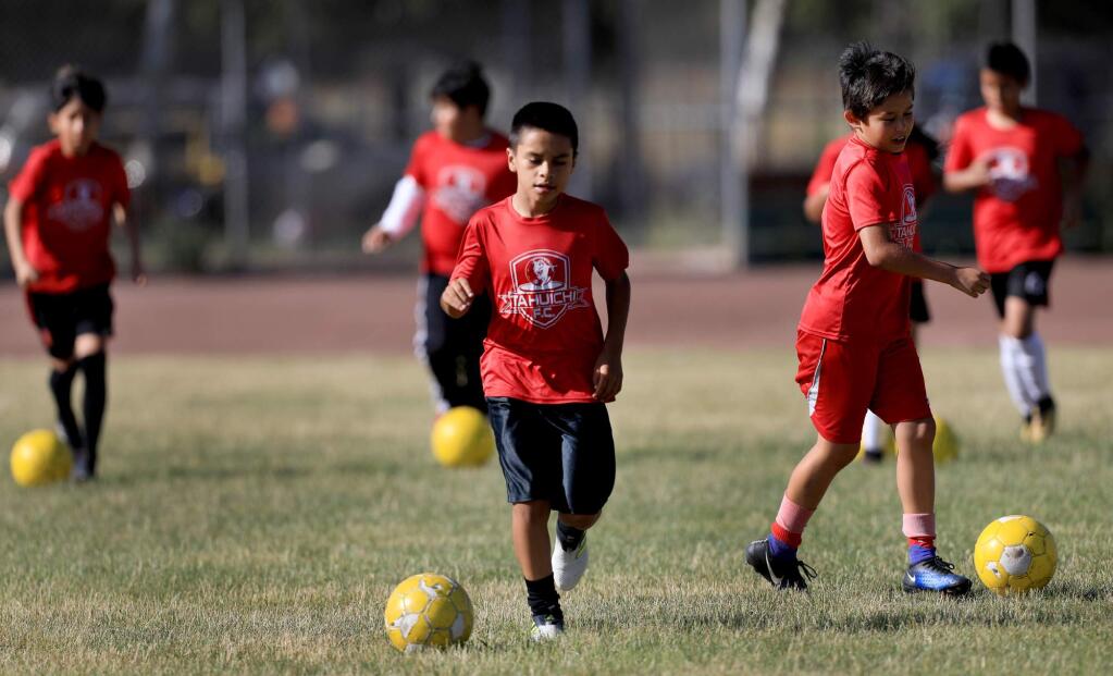 The Tahuichi Soccer Club's U-8 boys participate in dribble drills during the team's practice on the athletic fields of Elsie Allen High School, Thursday June 14, 2018 in Santa Rosa. (Kent Porter / The Press Democrat)