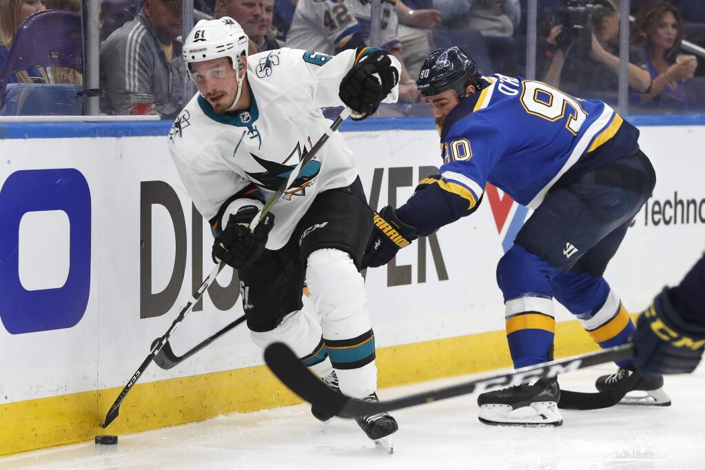 San Jose Sharks defenseman Justin Braun moves the puck ahead of St. Louis Blues center Ryan O'Reilly during the third period in Game 3 of the Stanley Cup Western Conference final series Wednesday, May 15, 2019, in St. Louis. (AP Photo/Jeff Roberson)