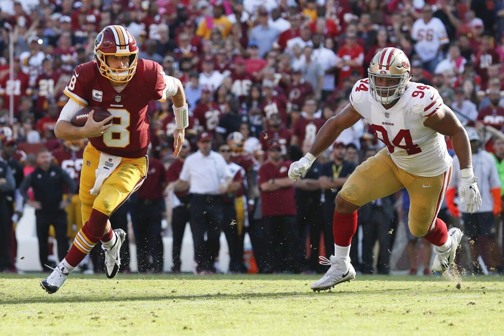 Washington Redskins quarterback Kirk Cousins carries the ball toward the end zone a touchdown as San Francisco 49ers defensive end Solomon Thomas looks on during the second half in Landover, Md., Sunday, Oct. 15, 2017. (AP Photo/Alex Brandon)