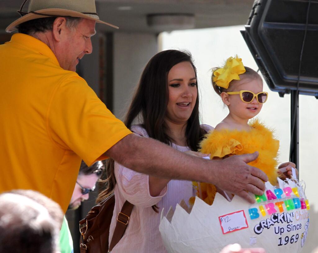 Steve Mahrt of Petaluma Egg Farm, helps first place winning contestant, Aurora Roland, 19 months old, with mom, Shelby Kelly, of Rohnert Park, as they participate in the 35th annual Cutest Little Chick in Town Contest, in Petaluma, on Saturday, April 27, 2019. (Photo by Darryl Bush / For The Press Democrat)