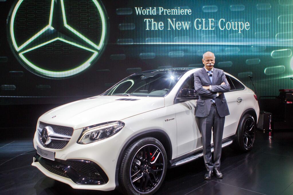 Dieter Zetsche, Daimler AG Chairman and head of Mercedes, pose for photos with the new GLE Coupe SUV at the North American International Auto Show, Monday, Jan. 12, 2015, in Detroit. (AP Photo/Tony Ding)