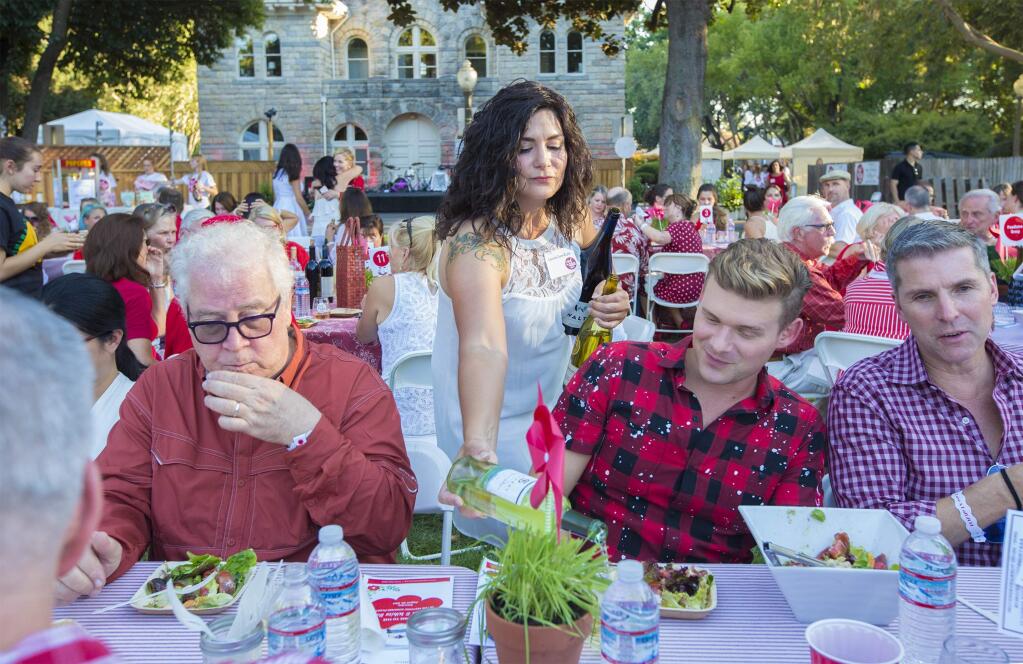 Volunteer Laura Lee Cole pours a cool white wine on a very hot evening for attendees of the 2017 Red and White Ball, which took place on Sonoma Plaza on Saturday, August 26,. Proceeds from the event will help support the many projects sponsored by the Sonoma Valley Education Foundation. (Photo by Robbi Pengelly/Index-Tribune)