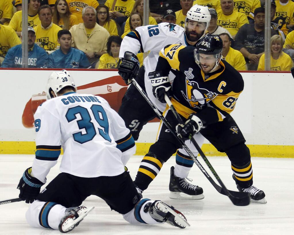 Pittsburgh Penguins' Sidney Crosby (87) tries to pass against San Jose Sharks' Logan Couture (39) and Patrick Marleau (12) during the first period of Game 1 of the Stanley Cup final series Monday, May 30, 2016, in Pittsburgh. (AP Photo/Keith Srakocic)