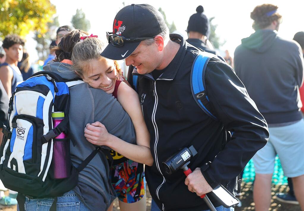 Healdsburg's Gabrielle Peterson is congratulated by her parents, Jim and Shannon Peterson, after winning the Division 5 girls race at the CIF Cross Country State Championships in Woodward Park in Fresno on Saturday, November 24, 2018. (Christopher Chung/ The Press Democrat)