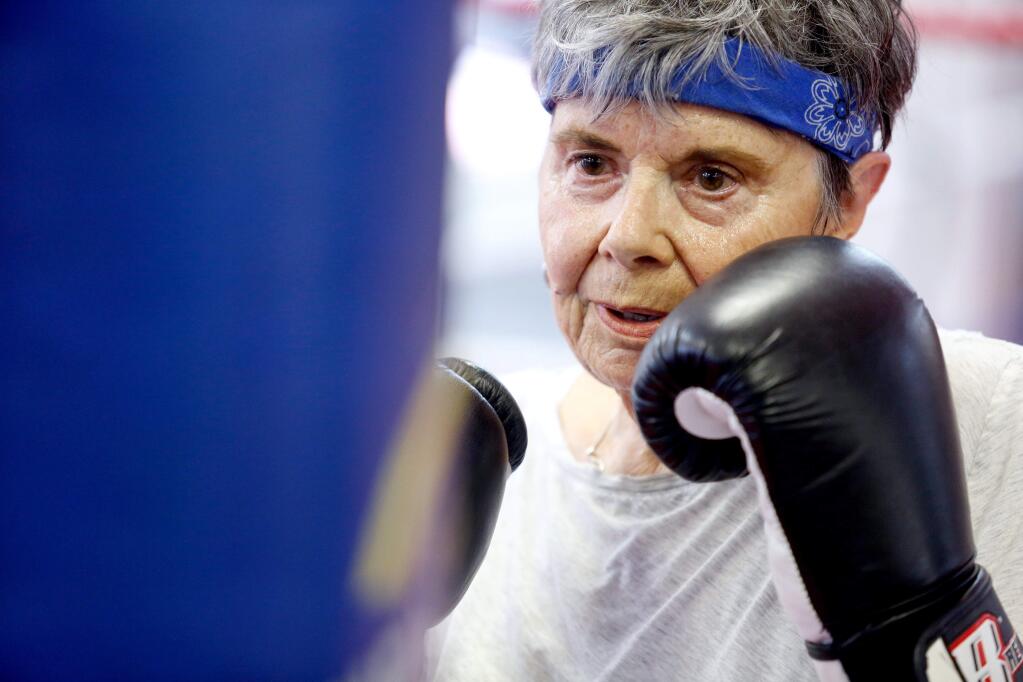 Pat Copass, 72, who was diagnosed with Parkinson's disease two-and-a-half years ago, punches a heavy bag during a Rock Steady Boxing class, a national program that uses boxing to help people control their Parkinson's disease symptoms, at CKS Martial Arts in Santa Rosa, California on Tuesday, June 21, 2016. (Alvin Jornada / The Press Democrat)