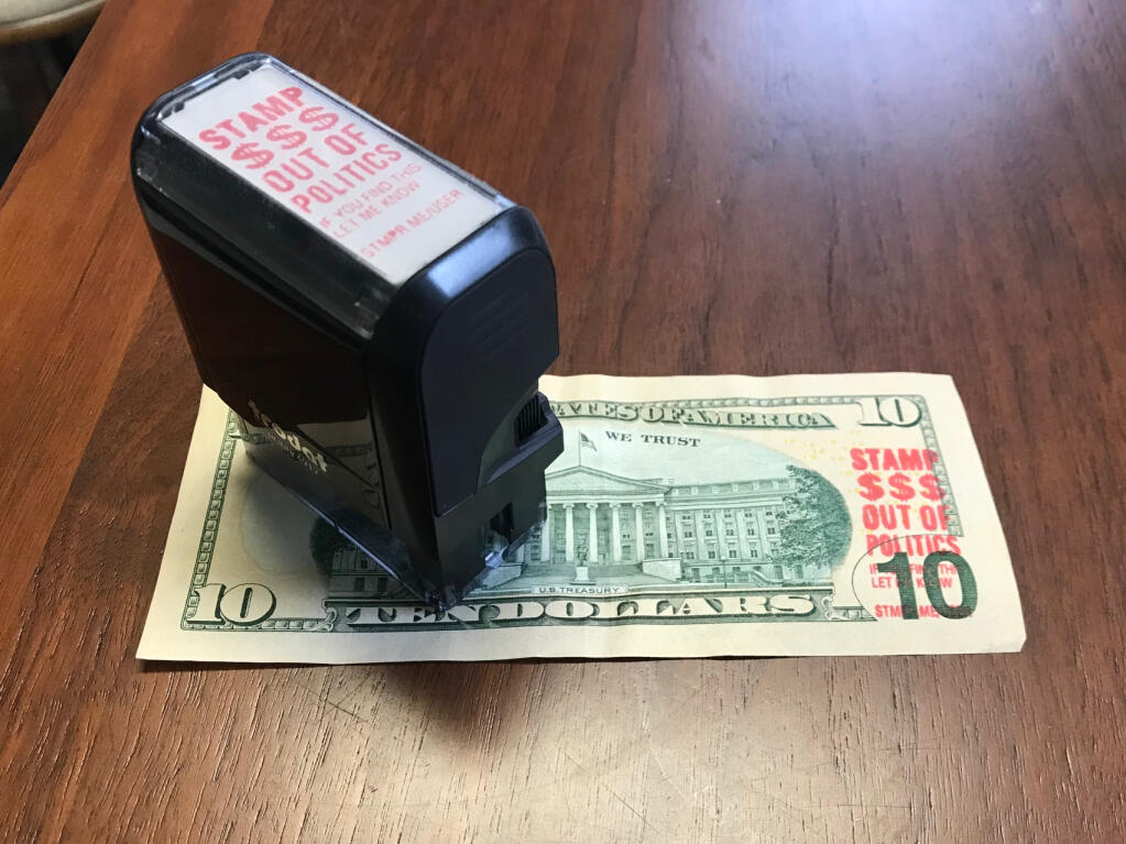 A red-ink stamper and a stamped $10 bill with a political message from Stamp Stampede. Other points of view are also appearing on currency and, while it may not be illegal, the bills can be removed and replaced by request. (Courtesy StampStampede.org)