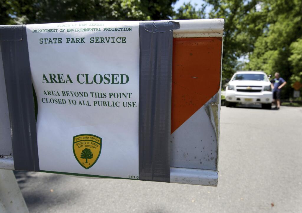 New Jersey State Park police block the entrance to Bulls Island state recreation area during the state government shutdown in Stockton, N.J. , Sunday, July 2, 2017. New Jersey's government shutdown dragged into a second day Sunday without a resolution to the stalemate between a defiant Republican Gov. Chris Christie and an unmoving Democratic Assembly Speaker Vincent Prieto. (Ed Murray/NJ Advance Media via AP)