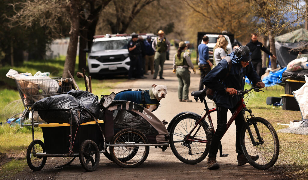 Everett Lincoln and his dog Damonia, leave the Joe Rodota Trail, Thursday, March 23, 2023 as county officials and Sonoma County Parks clear homeless encampments. (Kent Porter / The Press Democrat) 2023