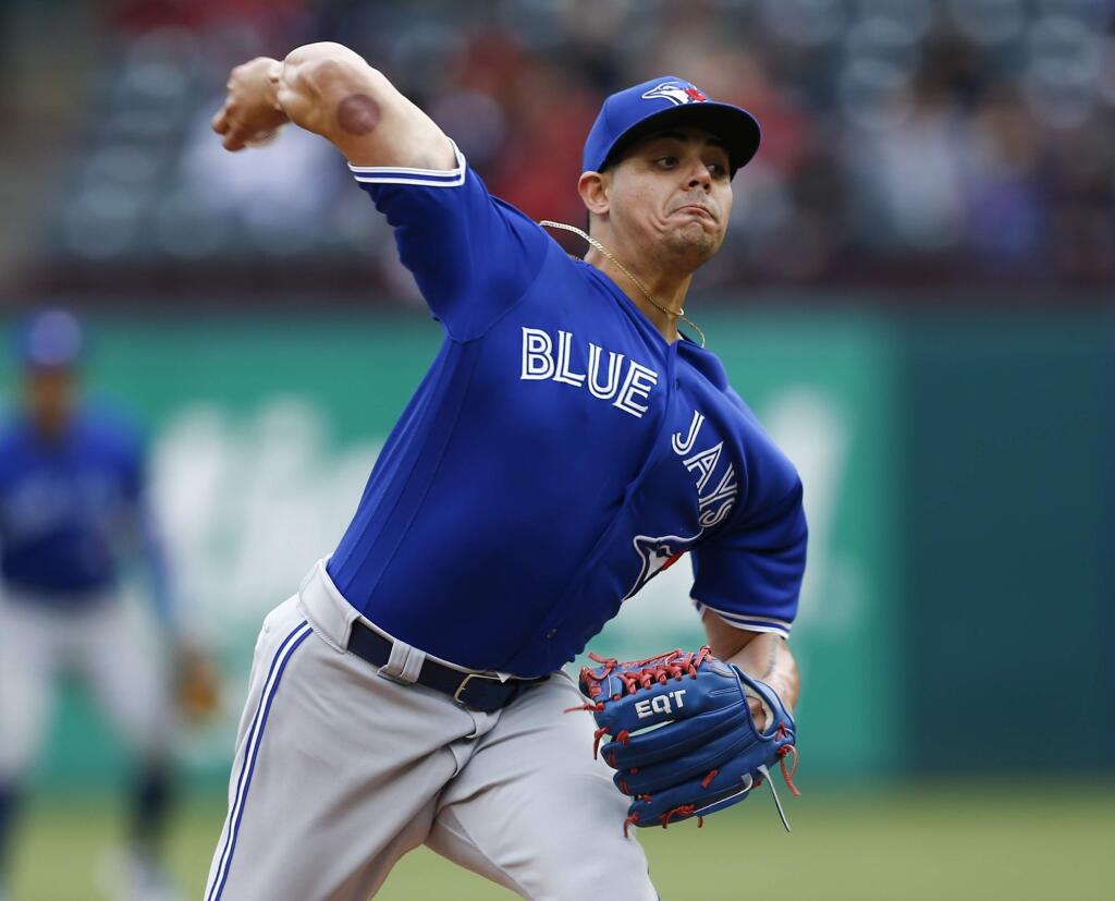 In this April 8, 2018, file photo, Toronto Blue Jays relief pitcher Roberto Osuna throws to a Texas Rangers batter during the ninth inning in Arlington, Texas. Baseball does not have a problem with Osuna returning from a domestic violence suspension while a legal charge could remain pending. Osuna agreed to a suspension through Aug. 4 under baseball's domestic violence policy. He has not pitched since May 6, two days before he was put on administrative leave when he was charged with one count of assault in Toronto. (AP Photo/Jim Cowsert, File)