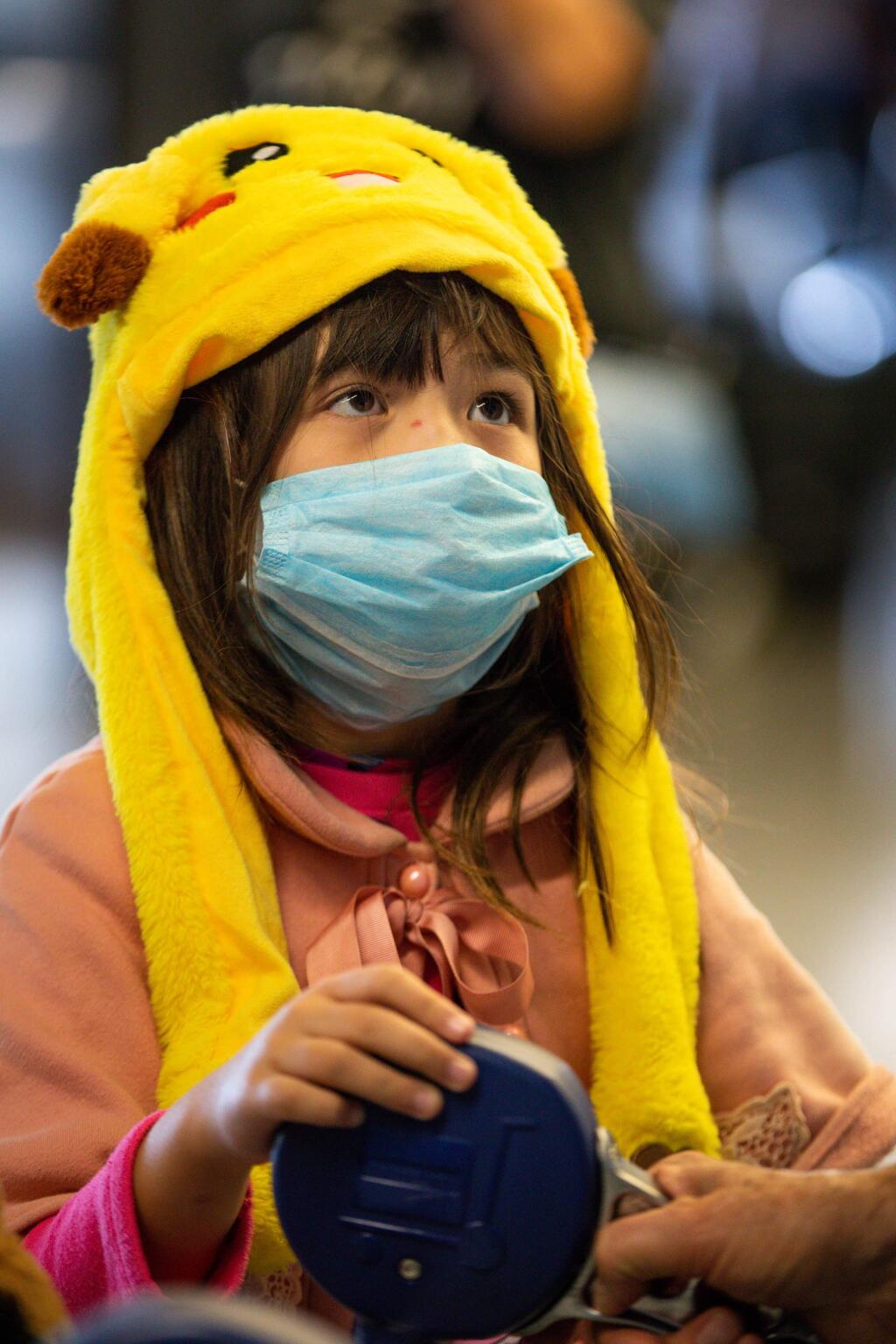 Daisy Johnston, 8, wears a face mask upon arriving to terminal G at San Francisco International Airport on Tuesday, Feb. 4, 2020. Daisy returned from China with her mother Amy Deng, who also wore a face mask because of the threat of the coronavirus. (Randy Vazquez/Bay Area News Group/TNS)