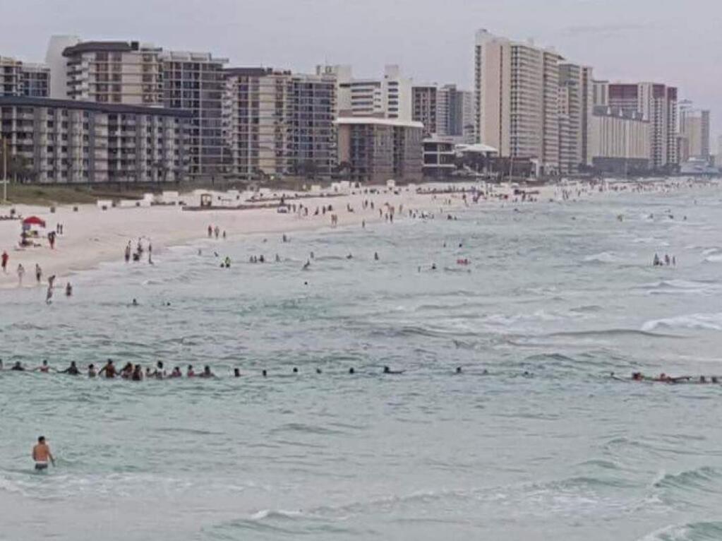 Dozens of beachgoers at Panama City Beach, Fla., form a human chain to rescue nine stranded swimmers swept away by a strong riptide on Saturday, July 8, 2017. (COURTESY OF ROBERTA URSREY)