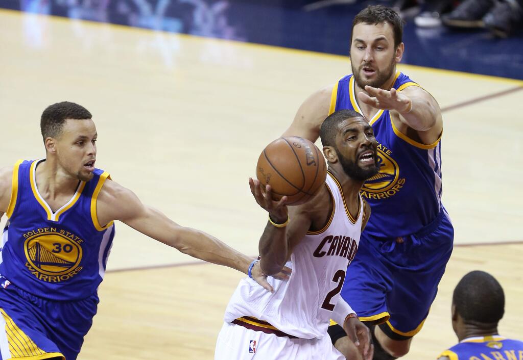 Cleveland Cavaliers' Kyrie Irving drives to the basket past Golden State Warriors' Stephen Curry and Andrew Bogut during their game in Cleveland on Wednesday, June 8, 2016. The Warriors lost to the Cavaliers 120-90. (Christopher Chung / The Press Democrat)