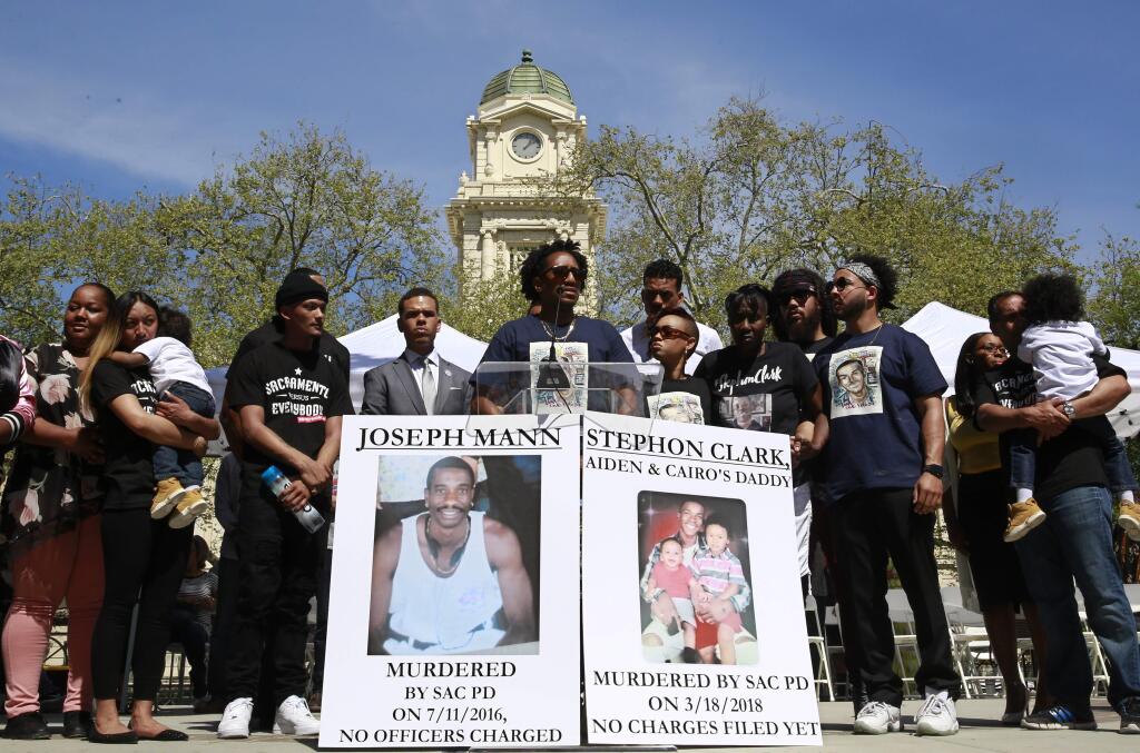 FILE - In this March 31, 2018 file photo, Curtis Gordon, center, the uncle of Stephon Clark, speaks at a rally aimed at ensuring Clark's memory and calling for police reform in Sacramento, Calif. The Sacramento County Coroner's Office official autopsy, released by Sacramento police, Tuesday, May 1, said Clark was shot seven times and was most likely approaching officers when they fired. That's a different conclusion than was reached by a private pathologist hired by the family. (AP Photo/Rich Pedroncelli, File)