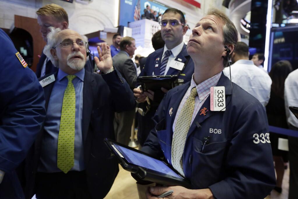 Traders Peter Tuchman, left, and Robert Charmak, right, work on the floor of the New York Stock Exchange, Wednesday, July 26, 2017. Stocks are opening higher on Wall Street as several big companies including Boeing and AT&T report solid results. (AP Photo/Richard Drew)