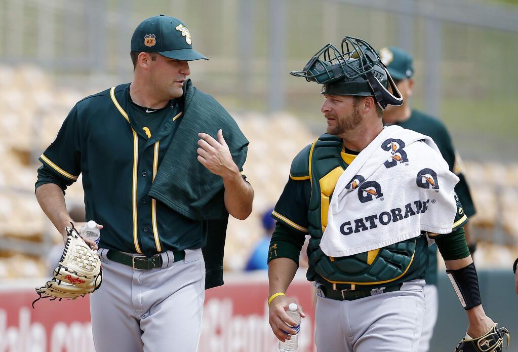 Oakland Athletics pitcher Andrew Triggs, left, talks with catcher Stephen Vogt after warming up in the bullpen prior to a spring training baseball game against the Chicago White Sox, Wednesday, March 22, 2017, in Glendale, Ariz. (AP Photo/Ross D. Franklin)