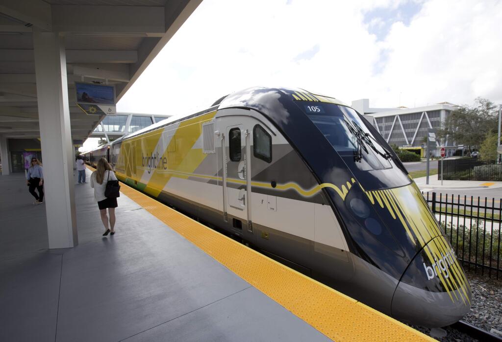 FILE - In this Jan. 11, 2018 file photo a Brightline train is shown at the station, in Fort Lauderdale, Fla. A plan to build a high-speed train between Southern California and Las Vegas is back on track now that a private rail company has taken over the project. Brightline announced Wednesday, Sept. 19, 2018, that it has acquired the rights to XpressWest's 185-mile federally approved rail corridor along Interstate 15. (AP Photo/Wilfredo Lee,File)