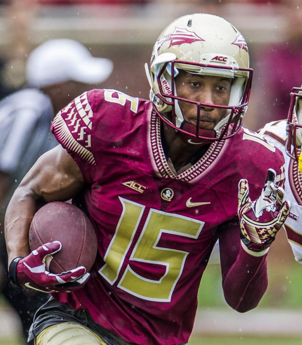 FILE - In this April 11, 2015, file photo, Florida State wide receiver Travis Rudolph run in the first half of the Florida State Garnet & Gold spring college football game in Tallahassee, Fla. A small gesture of kindness by Florida State University wide receiver Travis Rudolph - captured in a photo and shared on Facebook - had tears streaming down the face of the sixth-grader's mother, Leah Paske. 'I'm not sure what exactly made this incredibly kind man share a lunch table with my son, but I'm happy to say it will not soon be forgotten,' she wrote. (AP Photo/Mark Wallheiser, File)