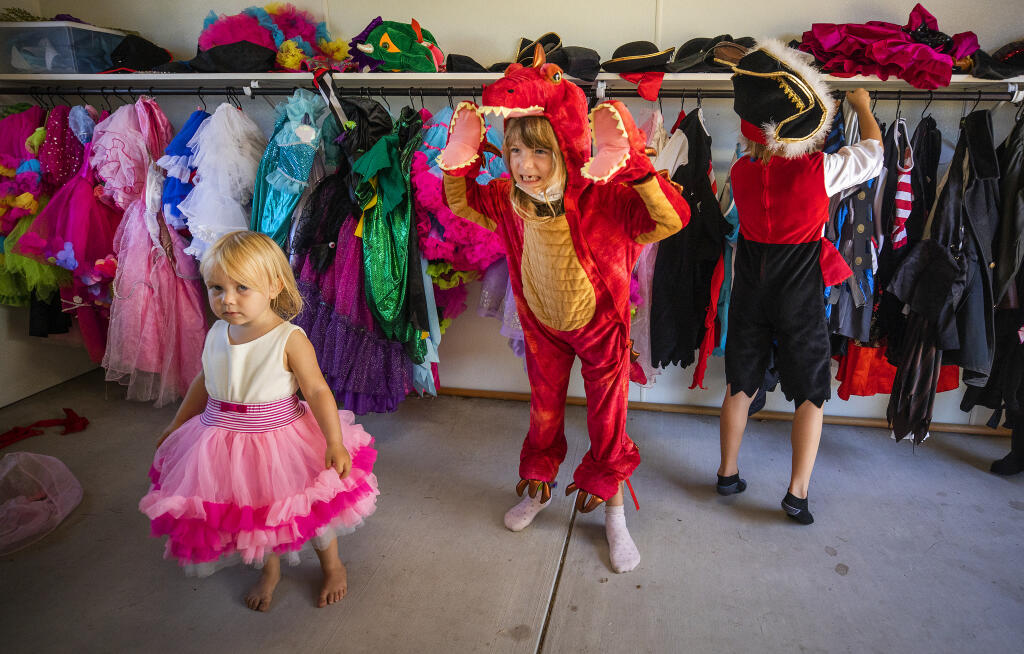 From left, Noel, 2, Cara, 6, and Nathaniel Mulert, who are visiting from their home on the island of Mauritius off the east coast of Africa, try one costumes in the Kids Play area at the Sonoma County Fair in Santa Rosa Thursday, August 11, 2020. (John Burgess/The Press Democrat)