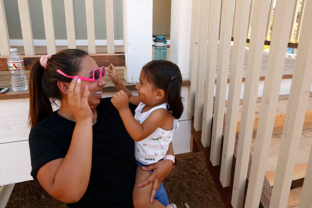 Estefani Cardenas plays with her daughter Mia, 2, before they walk through a house similar to the one being built for them, and other fire survivors, on the Medtronic Fountaingrove Campus, in Santa Rosa, California, on Friday, August 16, 2019. (Alvin Jornada / The Press Democrat)