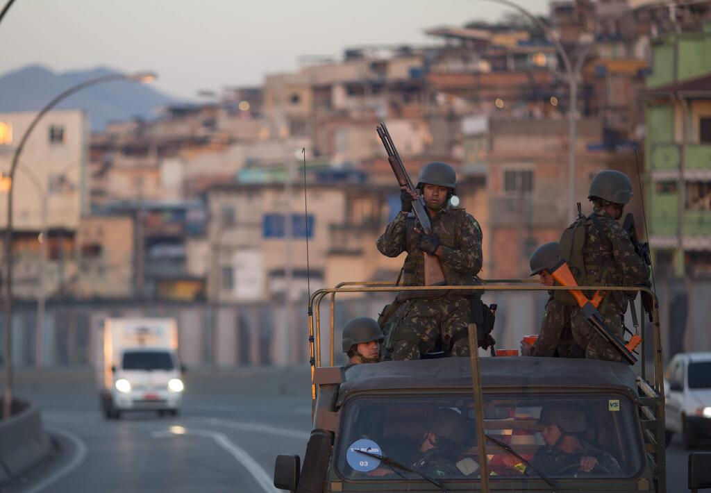 Soldiers patrol on a highway in the Mare Complex slums in Rio de Janeiro, Brazil, Sunday, July 24, 2016. Security has emerged as the top concern during the Olympics that will kick off on Aug. 5. (AP Photo/Leo Correa)