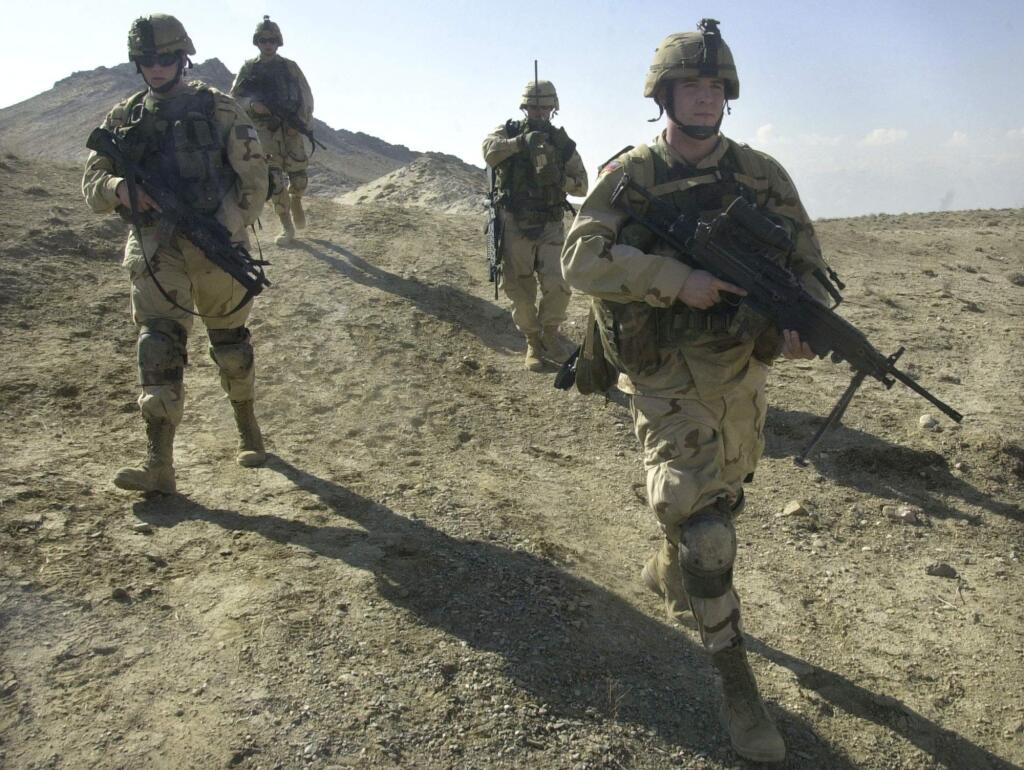 FILE - In this Feb. 11, 2003 file photo, U.S. soldiers patrol the perimeter of a weapons cache four miles of the US military base in Bagram, Afghanistan. Sixteen years of U.S. warfare in Afghanistan have left the insurgents as strong as ever and the nation's future precarious. Facing a quagmire, President Donald Trump on Monday will outline his strategy for a country that has historically snared great powers and defied easy solutions. (AP Photo/Aaron Favila, File)