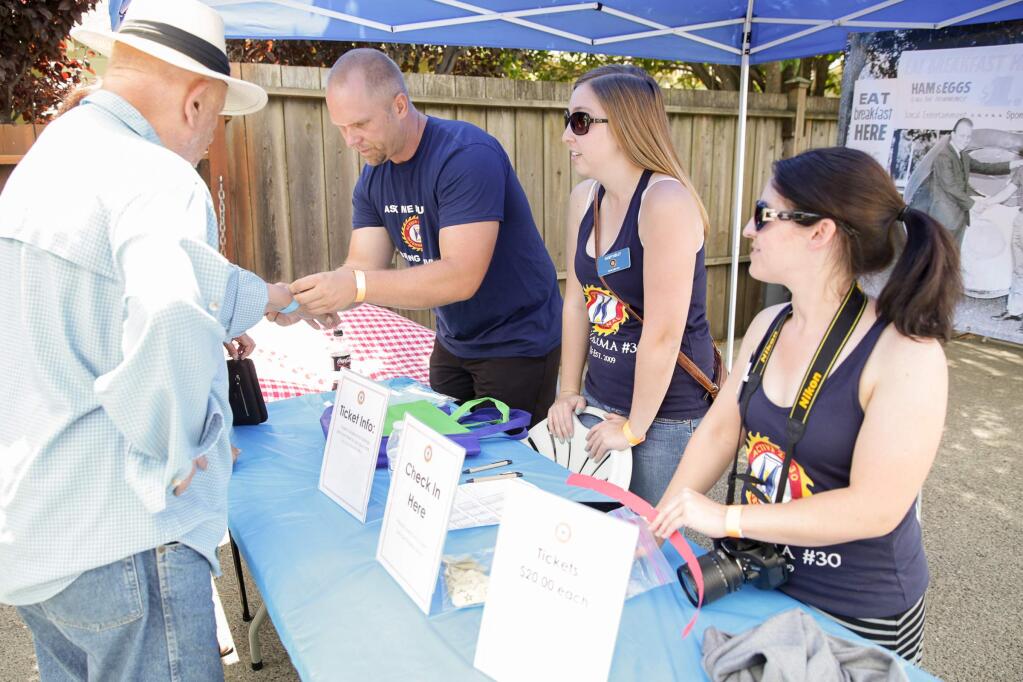 Paul Olbrantz, Casey Kelly and Stephanie Pavlos help hand out wrist bands and tickets to participants at the Petaluma Active 20-30's First Annual Rib Cook-Off at Mario & John's Tavern on Saturday, June 27, 2015. (RACHEL SIMPSON/FOR THE ARGUS-COURIER)