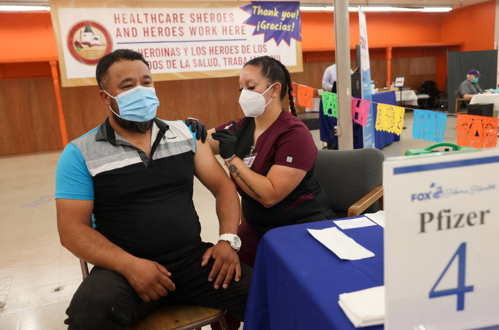 Medical assistant Ashley Simpson, right, administers the first dose of the Pfizer-BioNTech COVID-19 vaccine to Jesus Lopez at the Fox Home Health vaccination clinic in the Roseland area of Santa Rosa on Thursday, August 26, 2021.  (Christopher Chung/ The Press Democrat)