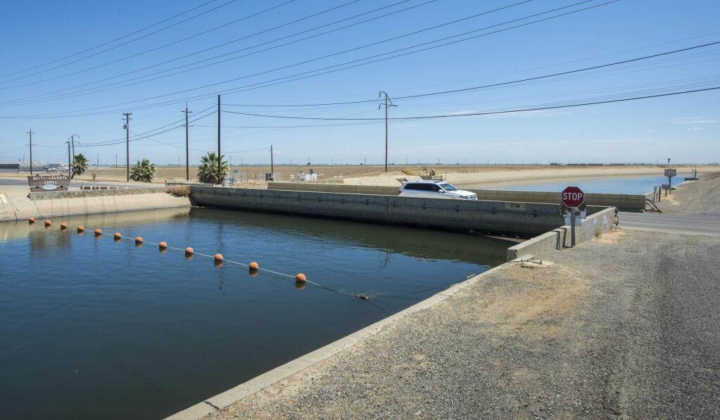 This July 23, 2015 photo provided by the California Department of Water Resources shows The Russell Avenue bridge, over the Delta Mendota Canal in Firebaugh, Calif., The drought has caused the bridge to subside until theres almost no space between bottom of bridge decking and canal water surface. A NASA scientist says in a report released Wednesday, Aug. 19, 2015 that parts of Californias Central Valley are sinking faster than ever as groundwater is being pumped during the states historic drought. (Florence Low/ California Department of Water Resources via AP)