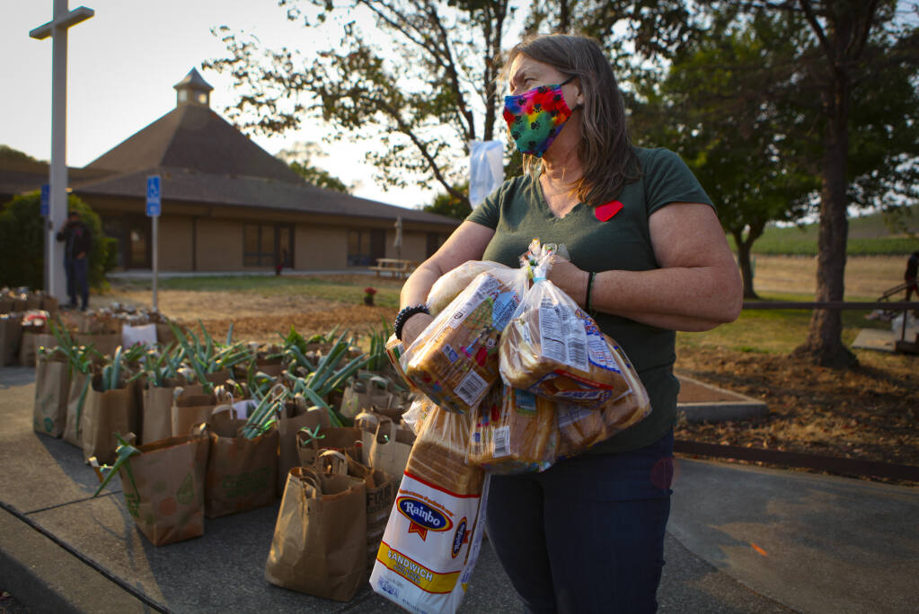 Lynne Gordon Moquete prepares bags for her nonprofit, Una-Vida’s, weekly food giveaway, every Tuesday at Hillside Church of the Nazarene.(CRISSY PASCUAL/ARGUS-COURIER STAFF)