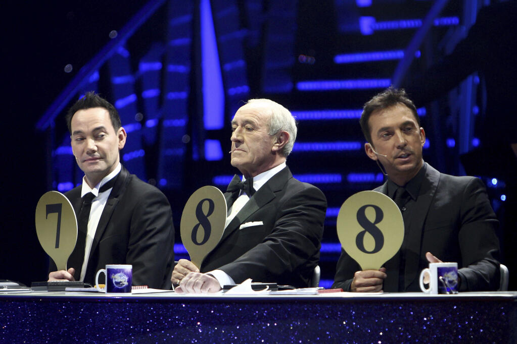 FILE - From left, judges Craig Revel Horwood, Len Goodman and Bruno Tonioli gesture, during the final dress rehearsal for the opening of the 'Strictly Come Dancing Live Tour' at the NIA, Birmingham, England, Jan. 20, 2012. Len Goodman, an urbane long-serving judge on “Dancing with the Stars” and “Strictly Come Dancing,” has died, his agent said Monday, April 24, 2023. He was 78. A former dancer, Goodman was a judge on “Strictly Come Dancing” for 12 years from its launch on the BBC in 2004. (David Jones/PA via AP, File)