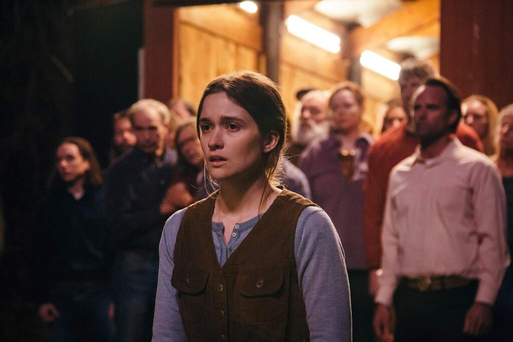 Alice Englert (center), as Mara, a young woman preparing for her wedding, and Walton Goggins, (right), as her father, the pastor of an isolated sect of Pentacostal serpent handlers deep in the Appalachian montains who willingly take up venomous snakes to prove themselves before God in 'Them That Follow.' (1091 Media)