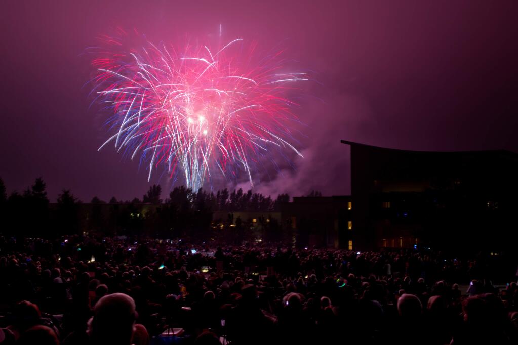 Fireworks illuminate hundreds of guests seated on the lawn behind Weill Hall to view the 4th of July Fireworks Spectacular at the Sonoma State University's Green Music Center in Rohnert Park, California on July 4, 2014. (Alvin Jornada / For The Press Democrat)