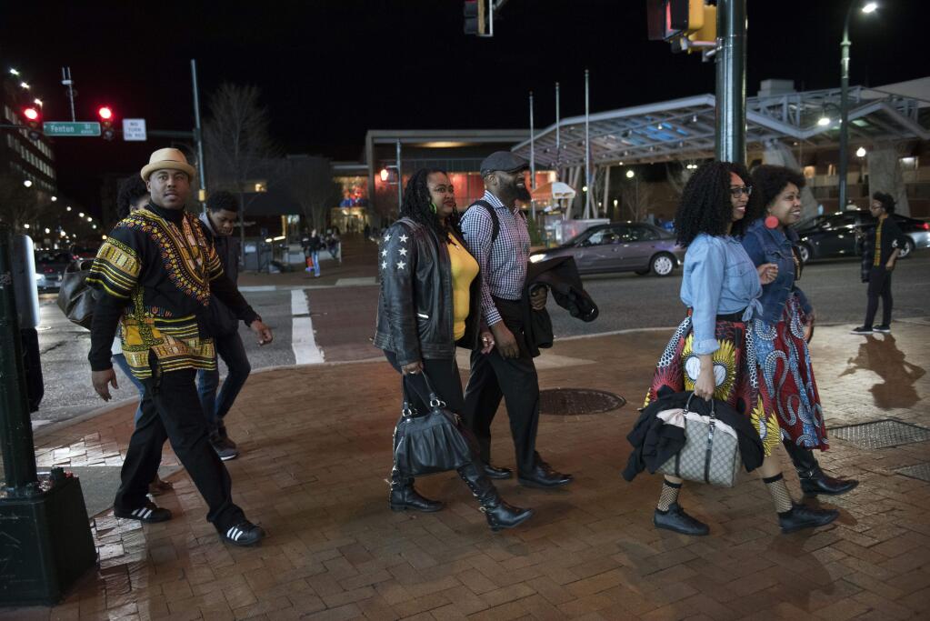 FILE - In this Feb. 15, 2018, file photo, Emanuel Lawton, left, and his family dressed in Wakanda-inspired attire arrive to see Black Panther in Silver Spring, Md. Just as 'Black Panther' is setting records at the box office, a new study finds that diverse audiences are driving most of the biggest blockbusters and many of the most-watched hits on television. UCLA's Bunche Center released its fifth annual study on diversity in the entertainment industry Tuesday, Feb. 27, unveiling an analysis of the top 200 theatrical film releases of 2016 and 1,251 broadcast, cable and digital platform TV shows from the 2015-2016 season. (AP Photo/Sait Serkan Gurbuz, File)