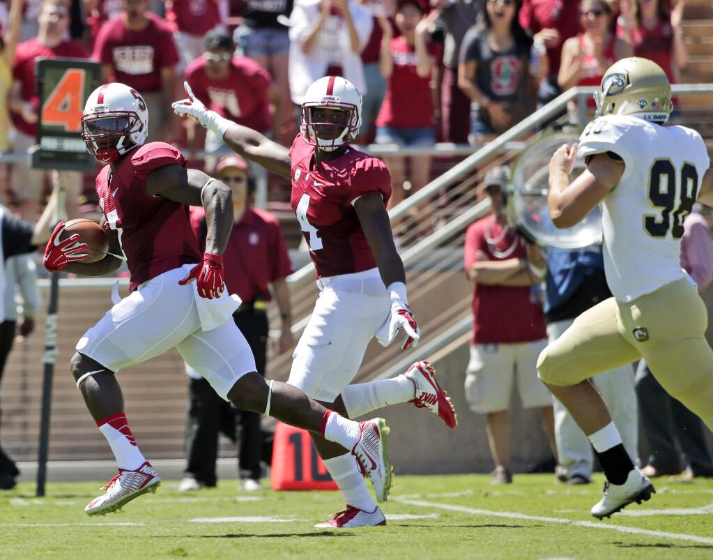 Stanford 's Ty Montgomery, left, returns a punt for a touchdown against UC Davis during the first half of an NCAA college football game on Saturday, Aug. 30, 2014, in Stanford , Calif. (AP Photo/Marcio Jose Sanchez)