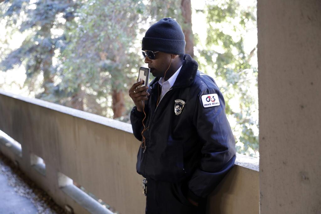 In this photo taken Oct. 26, 2017, Albert Brown III, who works as a security officer, talks to a friend after the end of his shift in San Carlos, Calif. Brown recently signed a lease for half of a $3,400 two-bedroom unit in Half Moon Bay, about 13 miles from his job. He can barely afford the rent on his $16-an-hour salary, even with overtime, but the car that doubled as his home needed a pricey repair and he found a landlord willing to overlook his lousy credit. (AP Photo/Marcio Jose Sanchez)