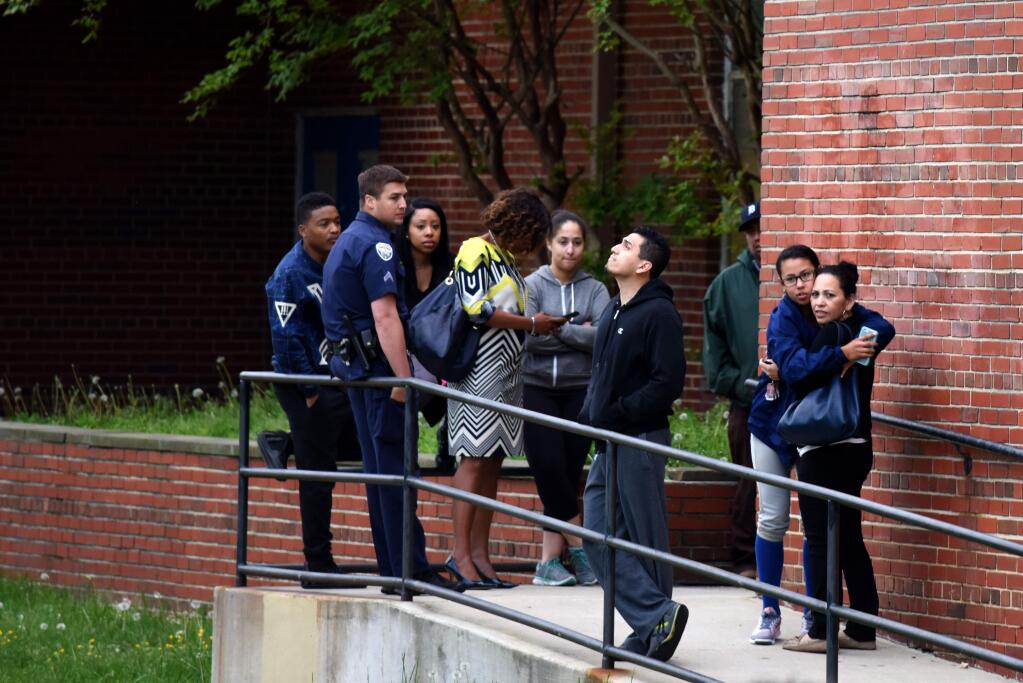 Parents and relatives gather outside the school cafeteria to pick up students in the wake of a shooting at High Point High School in Beltway, Md., Thursday, May 5, 2016. A man shot and killed a woman who was waiting to pick up her children in the parking lot of the suburban Washington high school Thursday and wounded a man who tried to intervene, police said. (Michael Robinson Chavez/The Washington Post via AP)