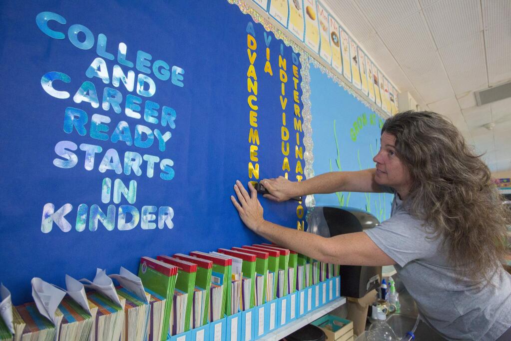 Dunbar Elementary School's Transitional kindergarten teacher Dawn McIntyre prepares her classroom for the pre-kinder group. The college her students will become familiar with is UC Davis. (Photo by Robbi Pengelly/Index-Tribune)