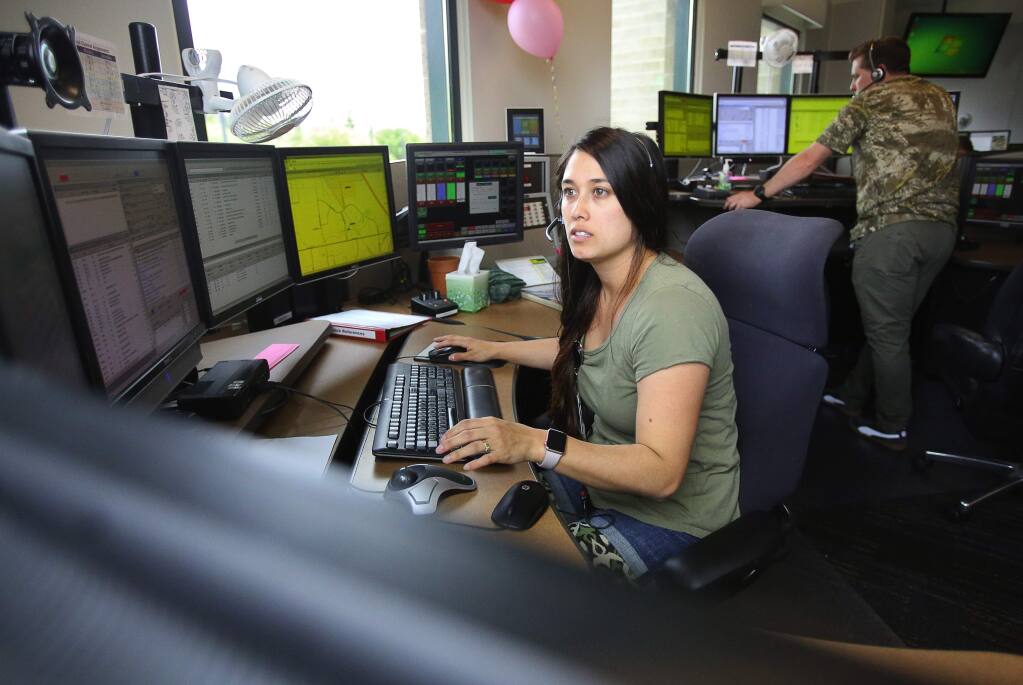 REDCOM communications dispatchers Krista Butts, left, and Brian Crabb receive emergency calls at their dispatch center in Santa Rosa on Monday, April 10, 2017. (Christopher Chung/ The Press Democrat)