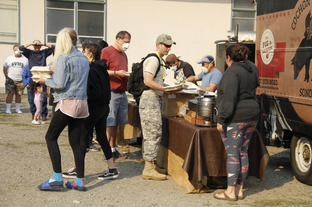 Evacuees line up for much-needed Cochon Volant barbecue this week at Sonoma Valley High School.