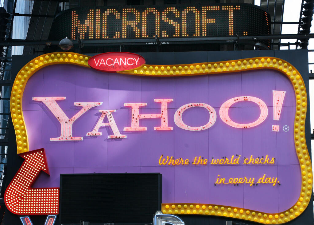 A Times Square news ticker flashes a headline about Microsoft above a billboard for Yahoo! in New York in this Friday, May 4, 2007 file photo. (AP Photo/Mark Lennihan, file)