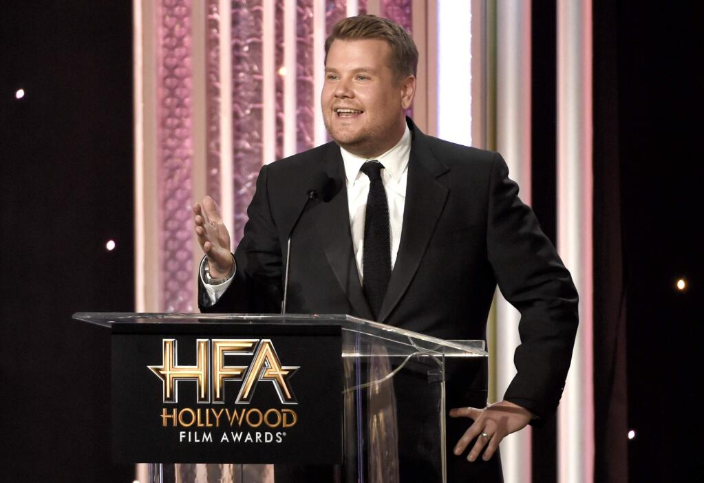 FILE - In this Nov. 6, 2016, file photo, host James Corden speaks at the 20th annual Hollywood Film Awards at the Beverly Hilton Hotel in Beverly Hills, Calif. Dick Clark Productions announced on Sept. 25, 2017, that Corden will return to host a third straight year when the awards are handed out on Nov. 5, 2017. (Photo by Chris Pizzello/Invision/AP, File)