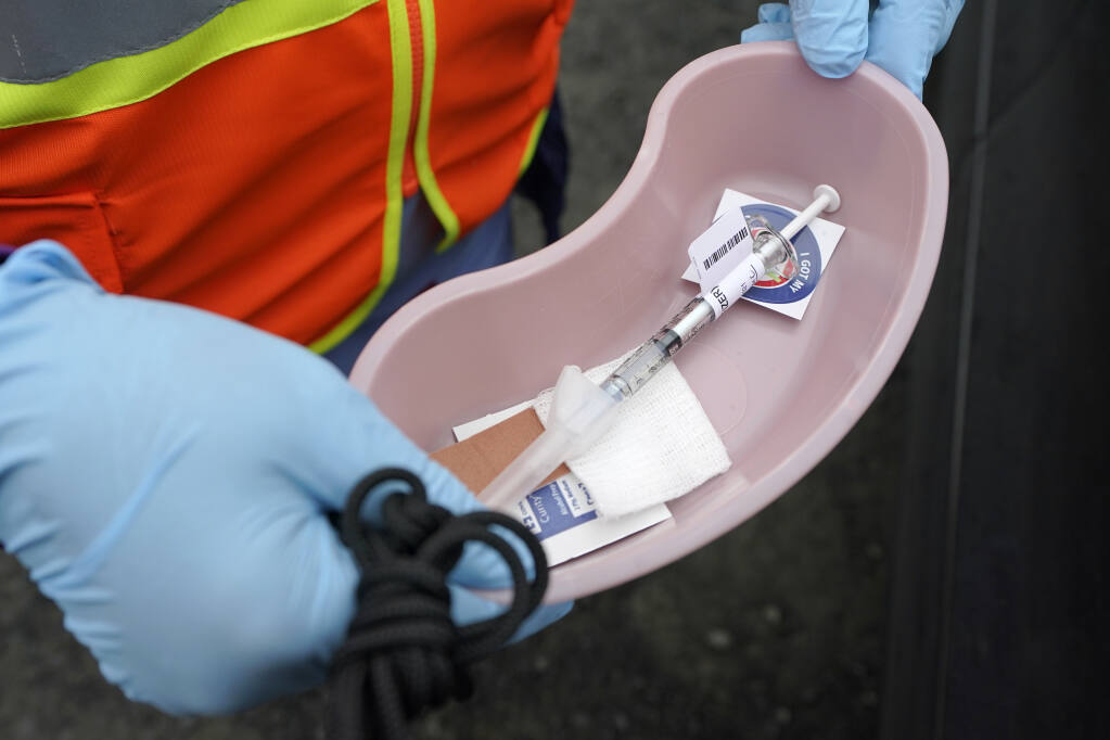 A nurse at a mobile vaccination clinic run by the VA Puget Sound Health Care System holds a tray with a dose of the Pfizer COVID-19 vaccine, Thursday, March 4, 2021, in Shelton, Wash.  (AP Photo/Ted S. Warren)