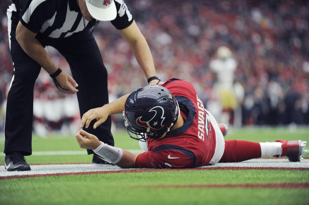 In this Sunday, Dec. 10, 2017, file photo, Houston Texans quarterback Tom Savage is checked by a referee after he was hit during the first half against the San Francisco 49ers in Houston. Savage left the game and it was later determined he had a concussion. (AP Photo/Eric Christian Smith, File)