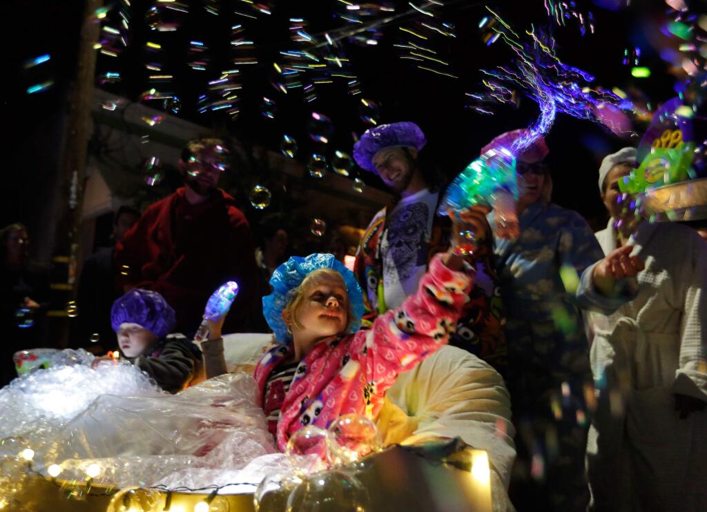 Rhiannon Pugh, 5, sprays bubbles in the air as she rides in a couch decorated as a bubble bath in the electric sofa parade during Winterblast at the South of A Street arts district in Santa Rosa, California on Saturday, November 14, 2015. (Alvin Jornada / The Press Democrat)