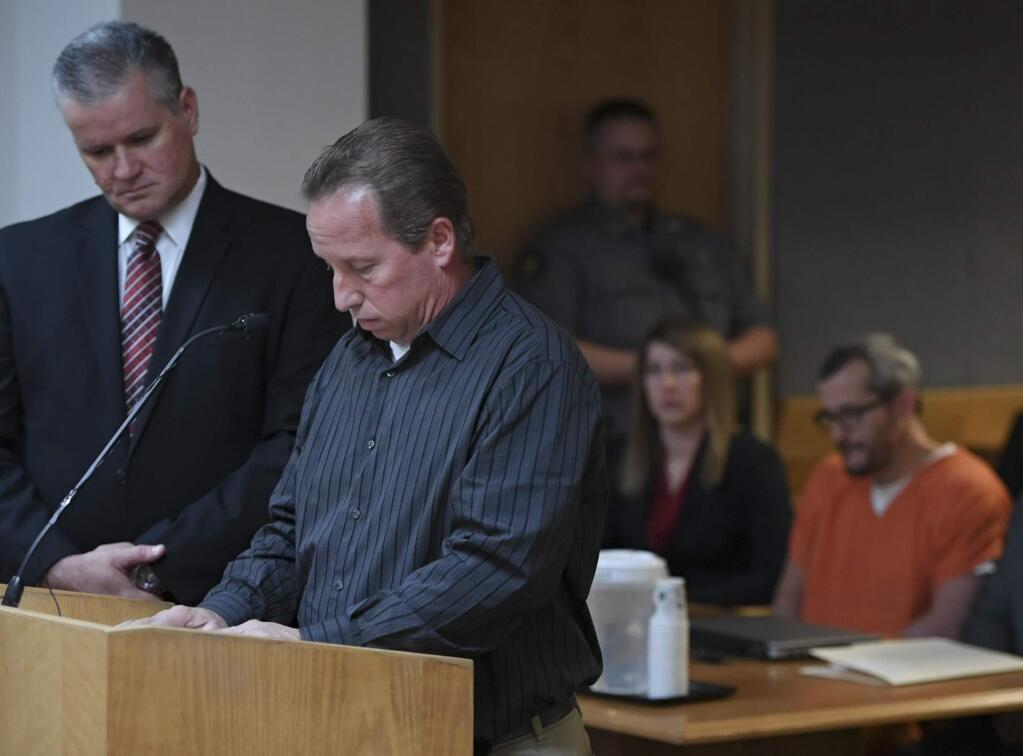 Michael J. Rourke, Weld County District Attorney, left, stands with Frank Rzucek, the father of Shanann Watts, as he reads a statement during court at the Weld County Courthouse on Monday, Nov. 19, 2018 in Greeley, Colo. Christopher Watts received three consecutive life sentences without a chance at parole on Monday, nearly two weeks after pleading guilty to avoid the death penalty. (RJ Sangosti/The Denver Post via AP, Pool)